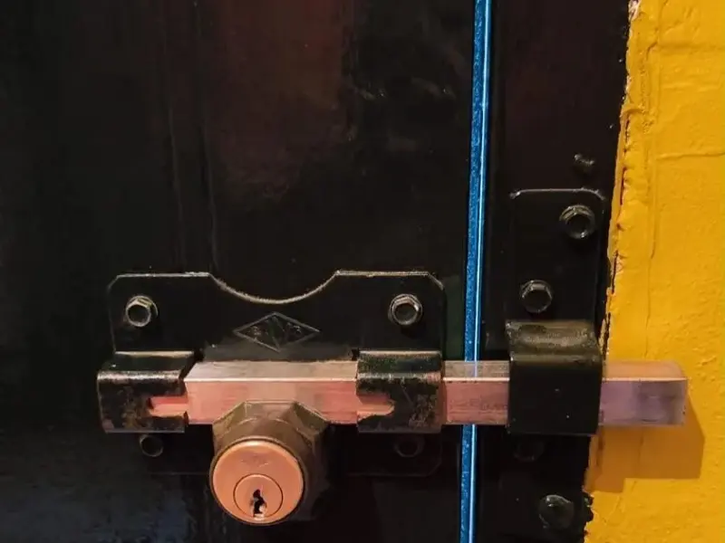 Cerrojo de seguridad con bombín en una puerta metálica